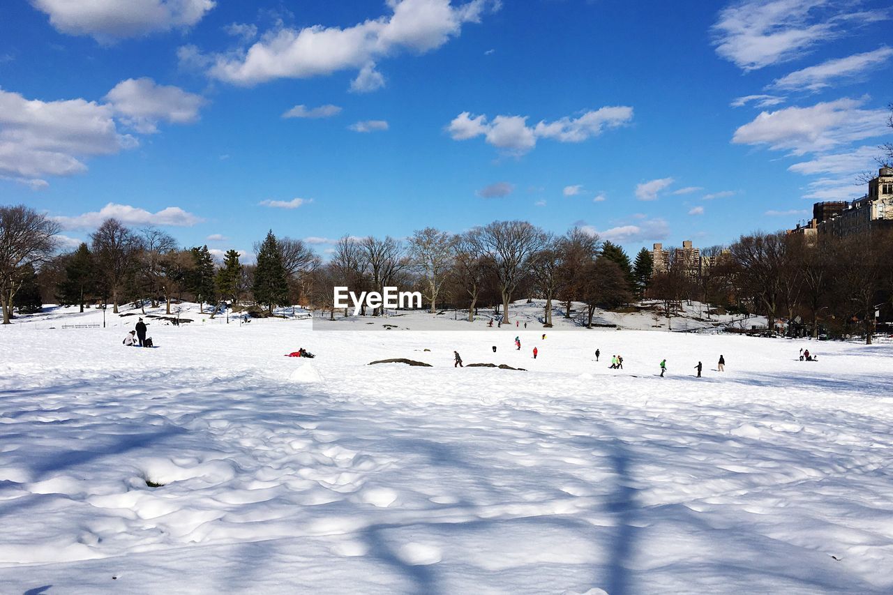 People skiing on snow against sky