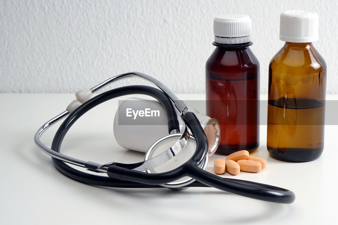 Close-up of stethoscope with medicines on table