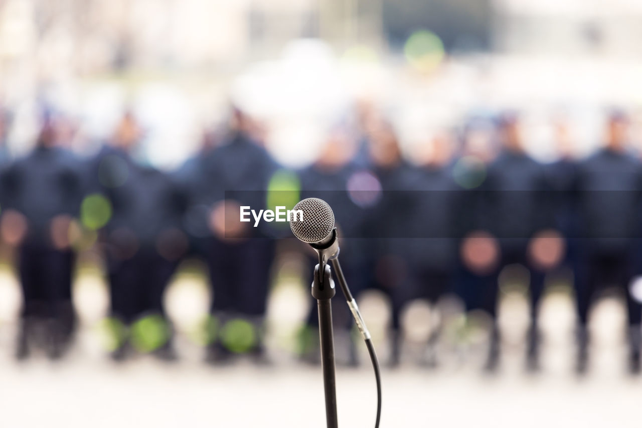 Focus on microphone, blurred crowd of people in the background