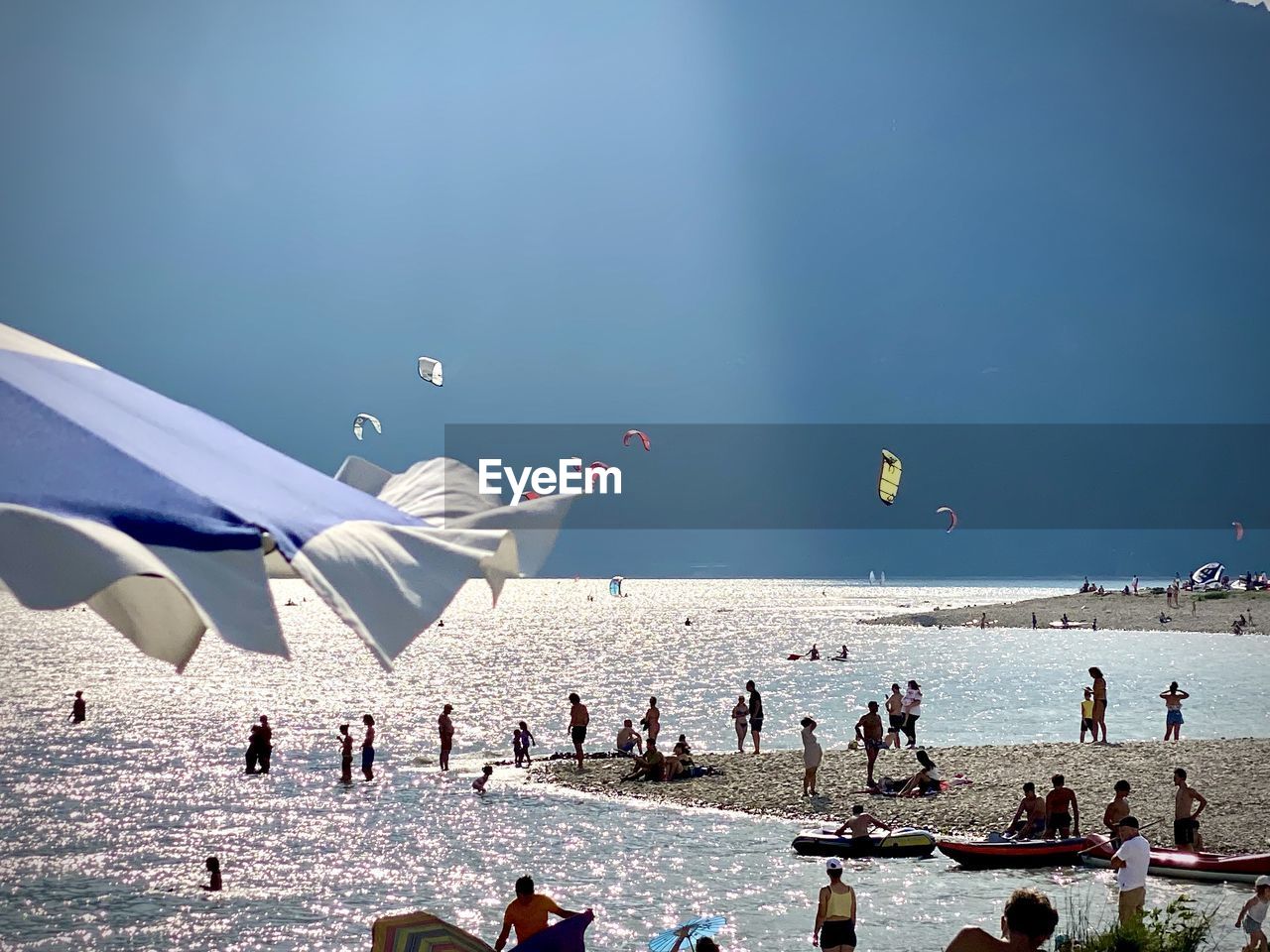 water, sea, crowd, sky, large group of people, group of people, nature, beach, land, travel, vacation, trip, holiday, travel destinations, day, leisure activity, flying, blue, tourism, outdoors, ocean, men, sunlight, lifestyles, summer, beauty in nature, vehicle, enjoyment