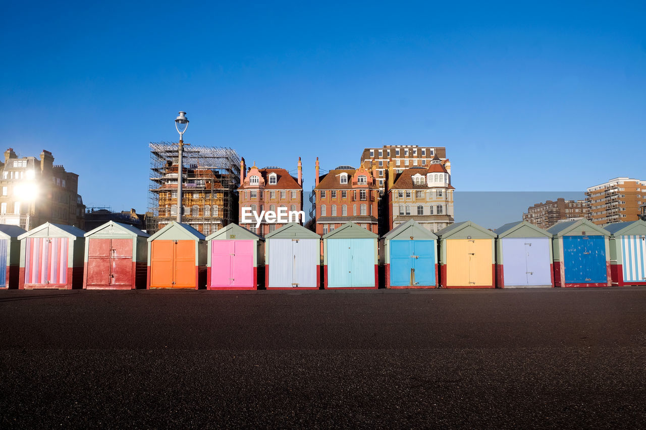 Colorful huts at beach against blue sky