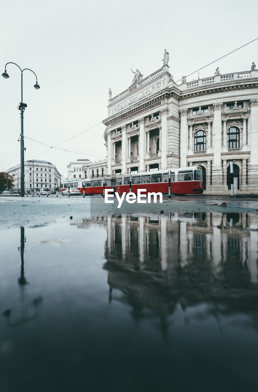 Tramway moving by reflection of building in river