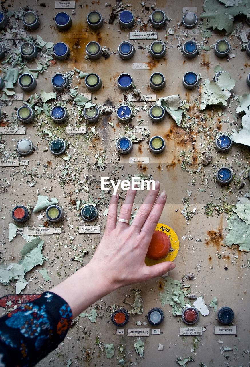 Close-up of woman pressing button of weathered machine