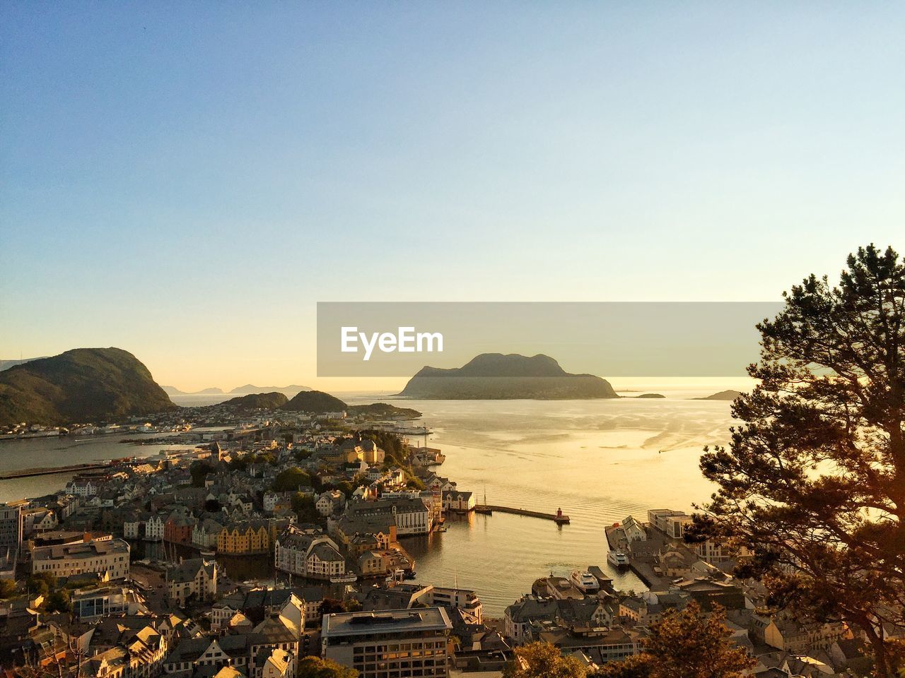 Aerial view of city by sea against clear sky