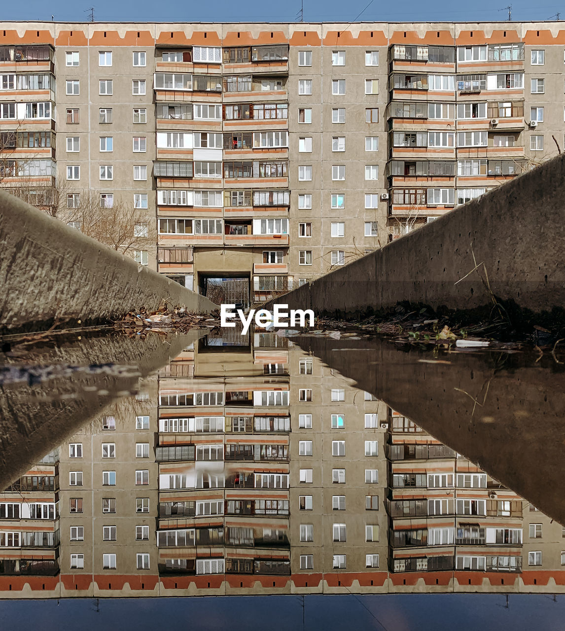 Reflection of buildings in puddle on street