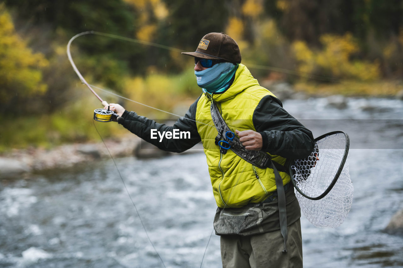 Man fly fishing at roaring fork river in forest