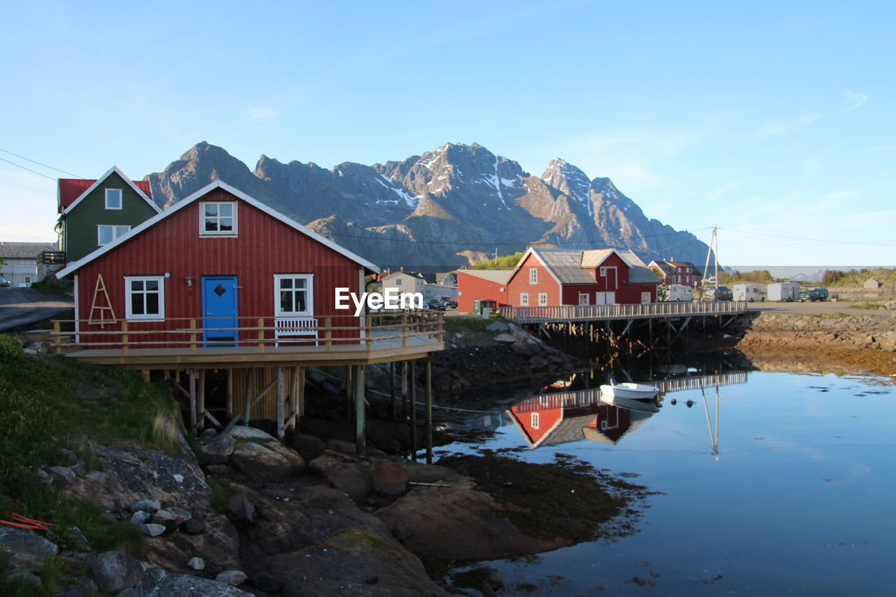 Stilt houses in lake against sky