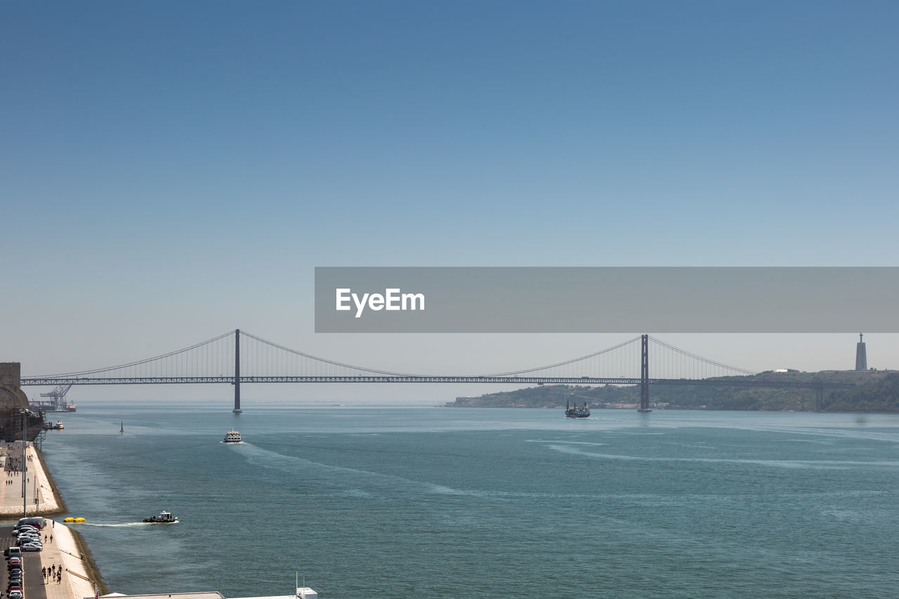 SUSPENSION BRIDGE OVER SEA AGAINST SKY