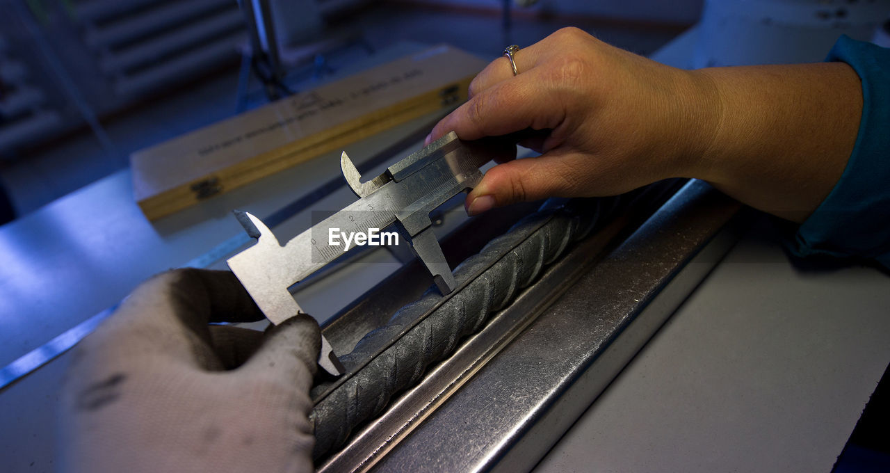 Cropped image of hands using vernier calliper in workshop