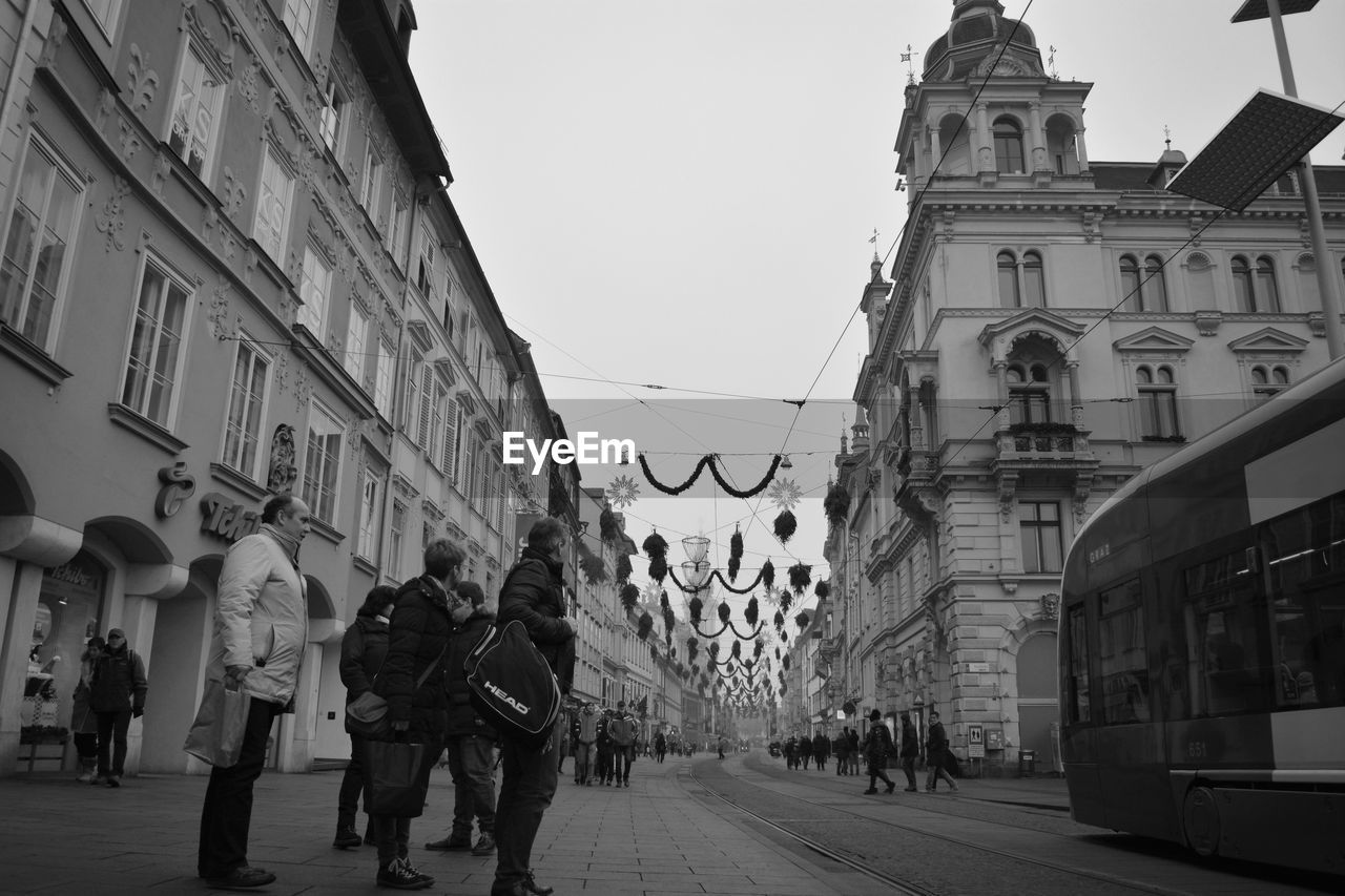 PEOPLE WALKING ON STREET IN CITY