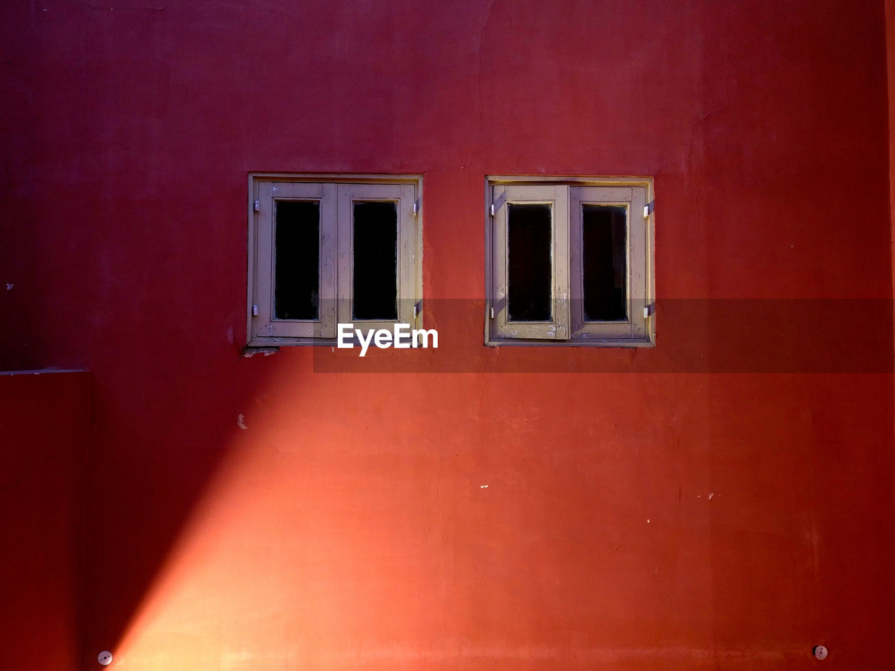 LOW ANGLE VIEW OF RED WALL WITH BUILDING