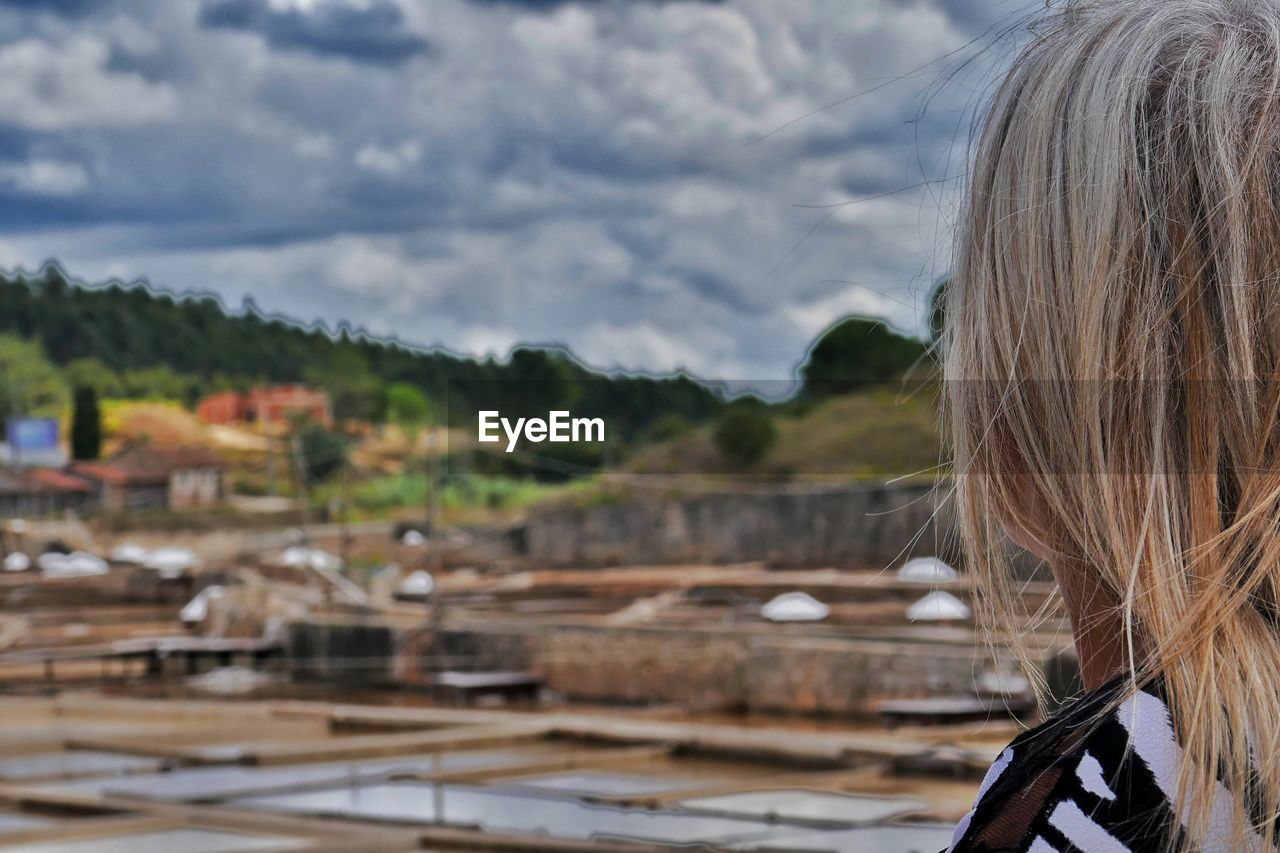 Rear view of woman looking away standing against sky