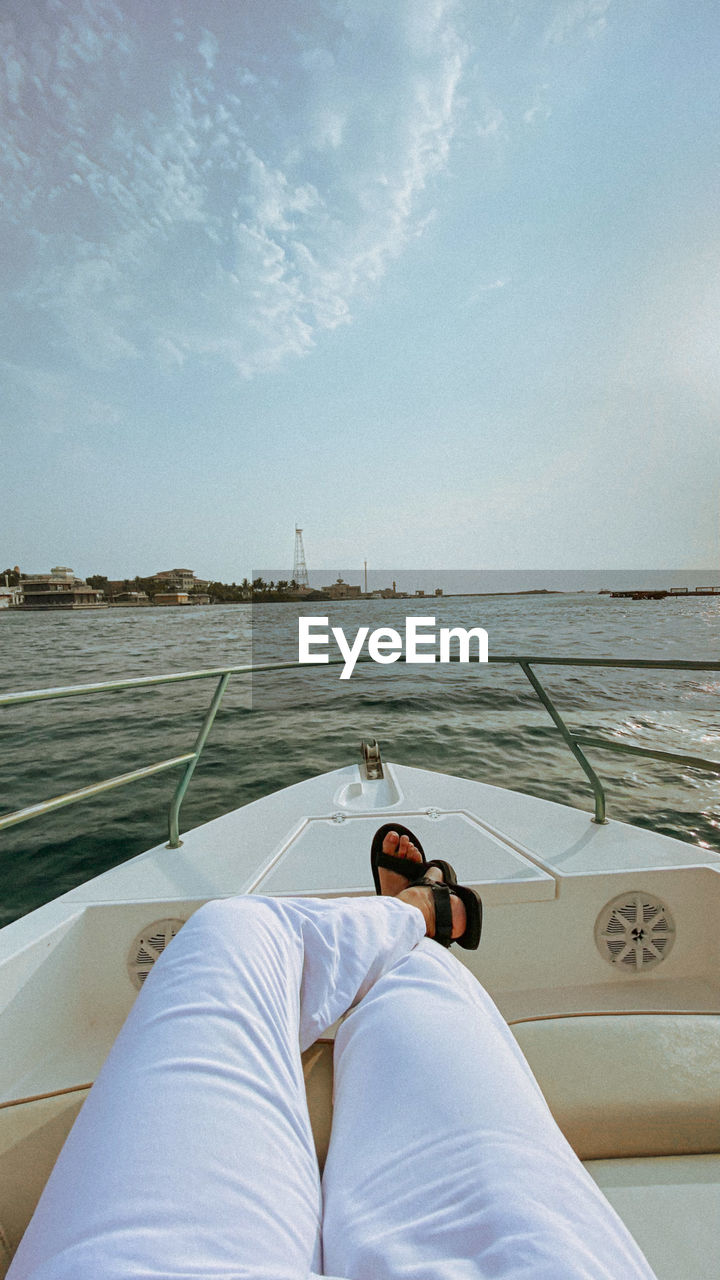 water, boat, sky, transportation, vehicle, sea, nautical vessel, mode of transportation, nature, relaxation, travel, one person, vacation, adult, trip, leisure activity, holiday, watercraft, day, lying down, personal perspective, lifestyles, ship, men, outdoors, tranquility, travel destinations, cloud, sunlight, summer, scenics - nature, luxury