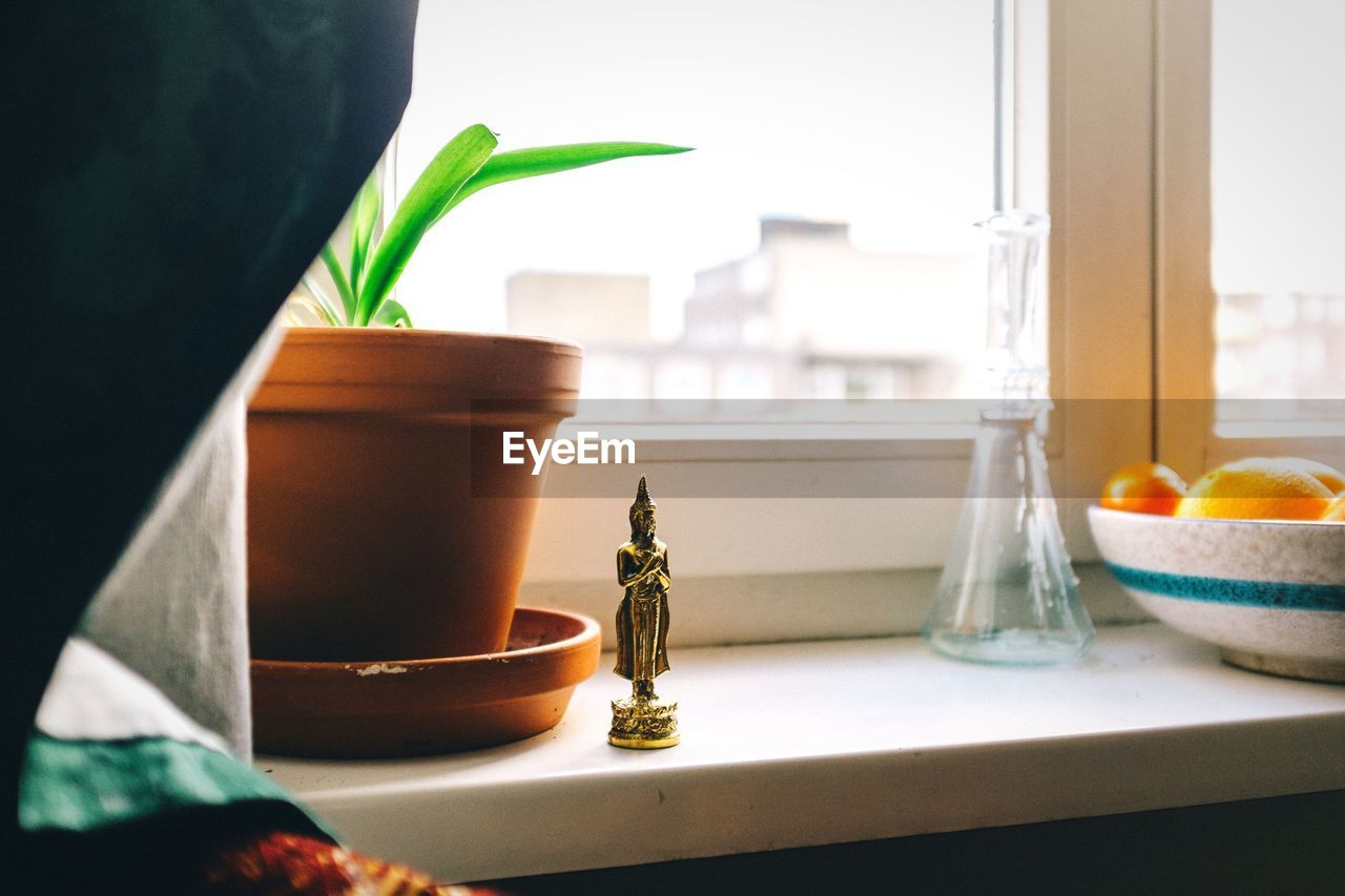 Close-up of buddha statue on window sill