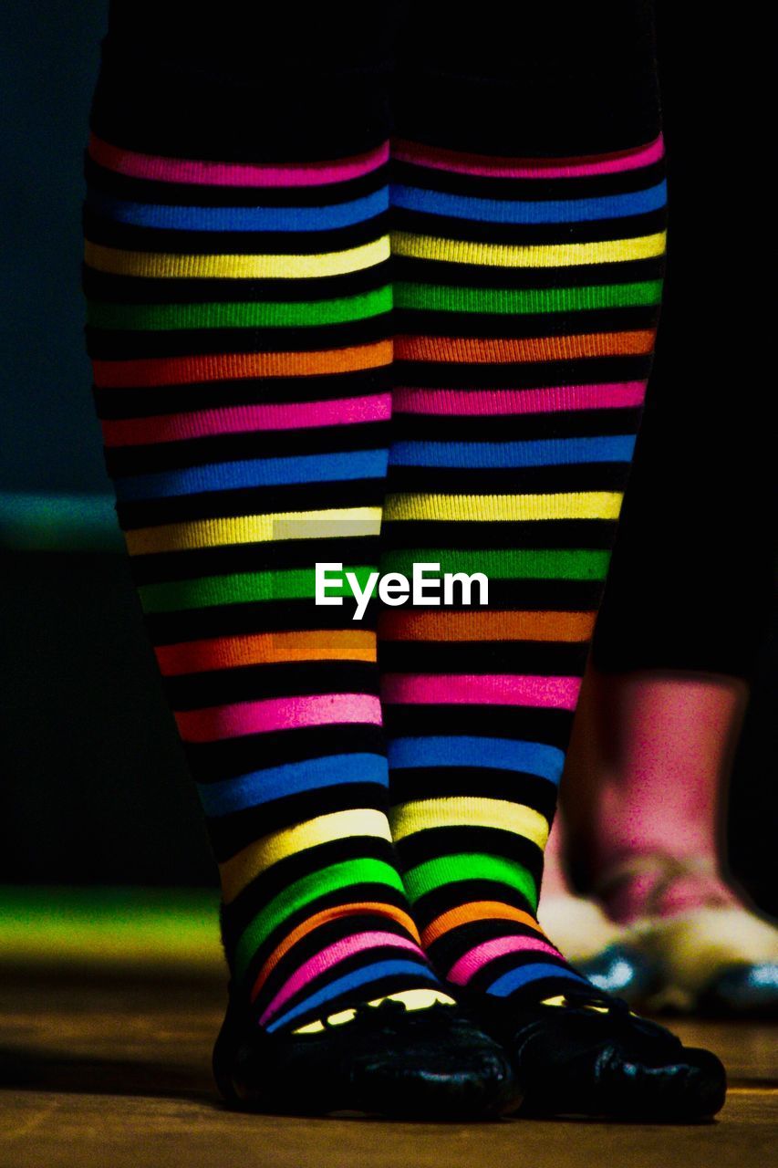 Low section of woman wearing multi colored socks 