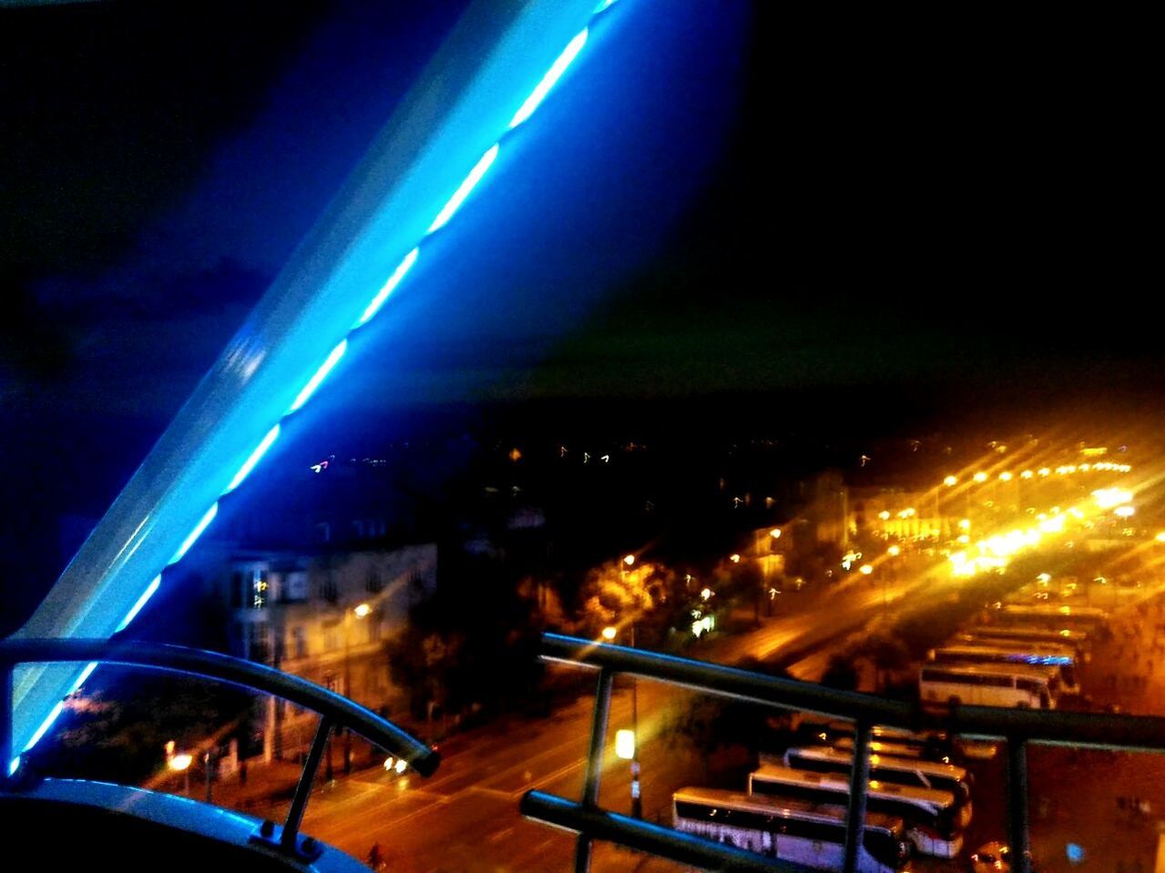 ILLUMINATED CITY STREET AGAINST BLUE SKY