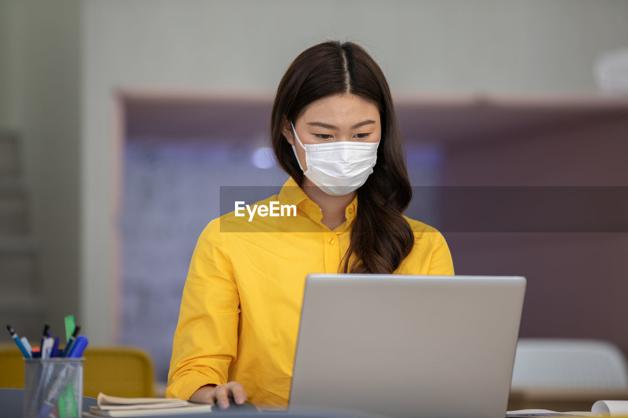 Businesswoman wearing mask working in office