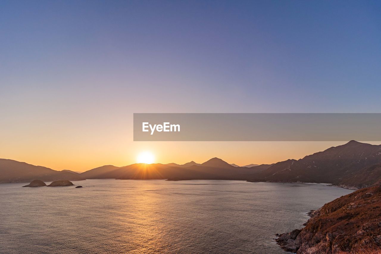 Scenic view of sea against clear sky during sunset