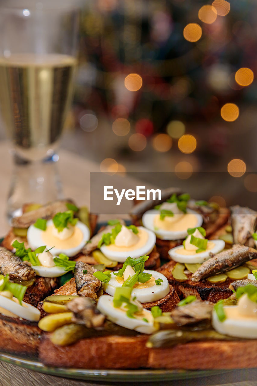 Toasted bread with sprats, eggs and herbs. traditional russian food for the new year's table.