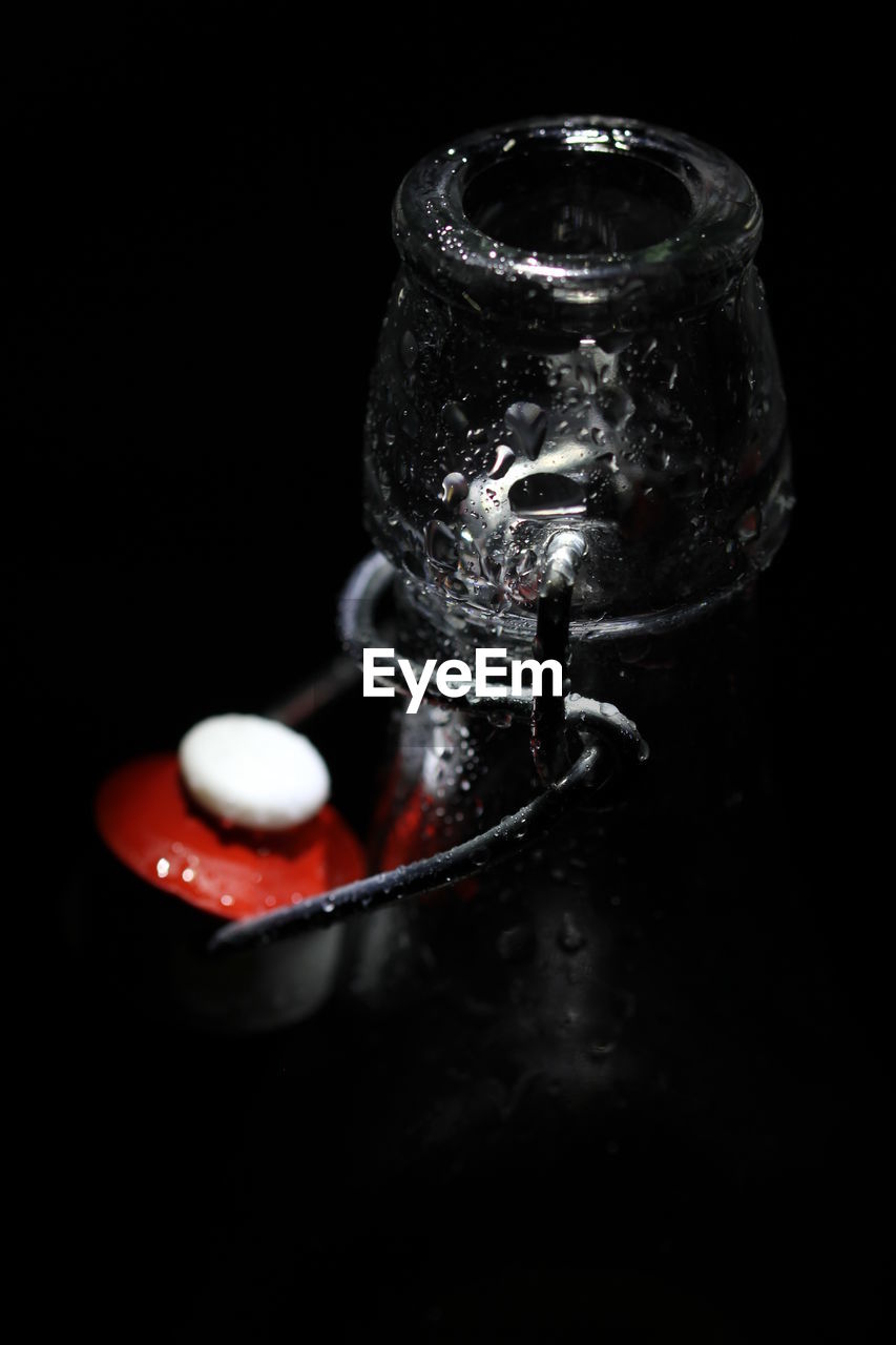 Close-up of glass water bottle against black background