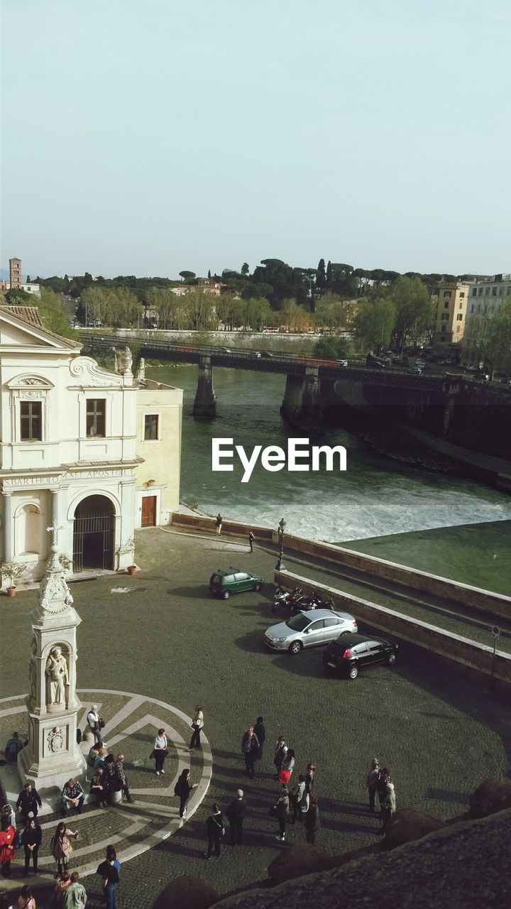 PEOPLE ON BRIDGE IN CITY AGAINST SKY