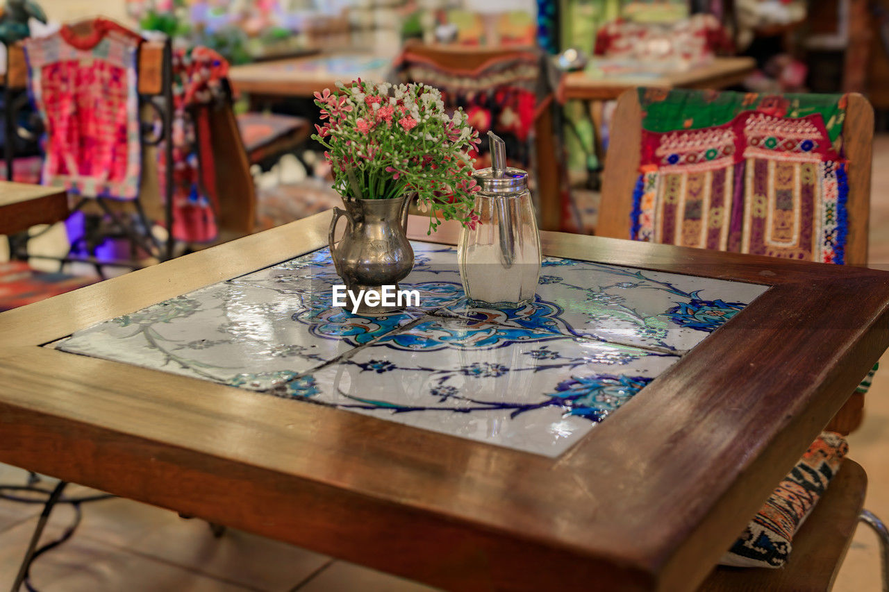 table, art, indoors, no people, flower, furniture, plant, business, wood, seat, flowering plant, focus on foreground, room