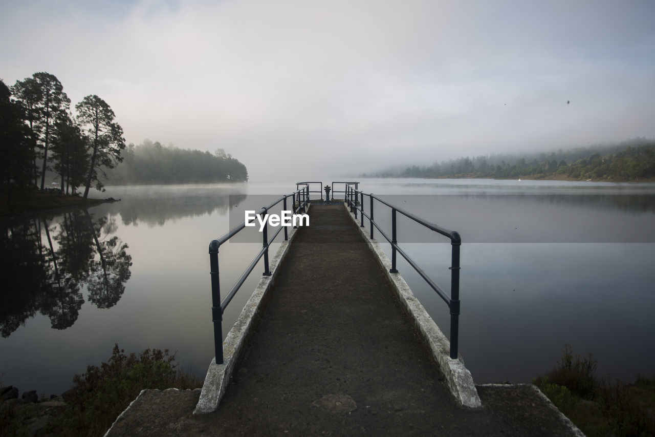 Pier over lake against sky