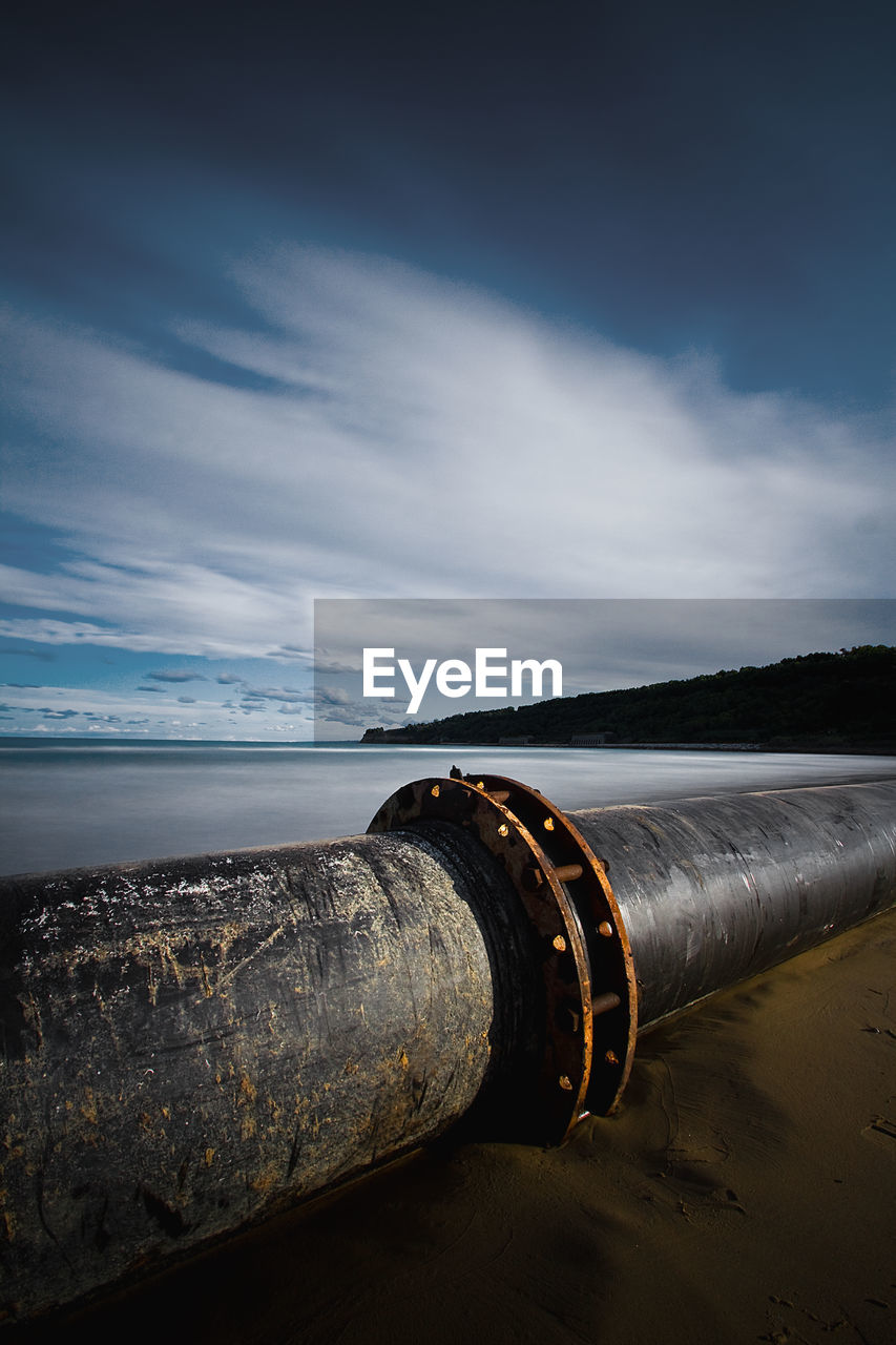 Pipeline at beach against sky