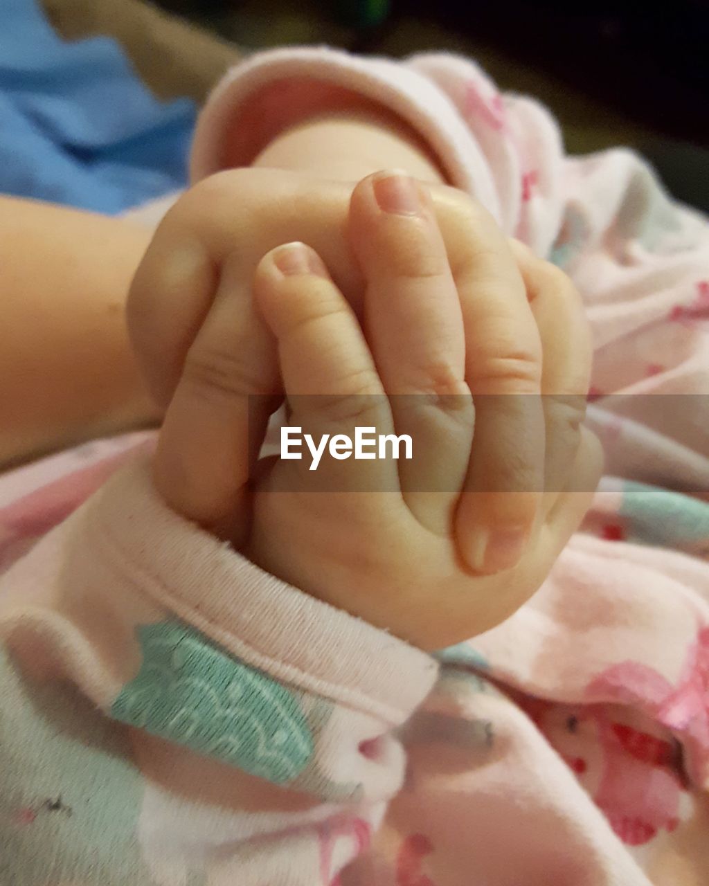 Close-up of baby hand on bed