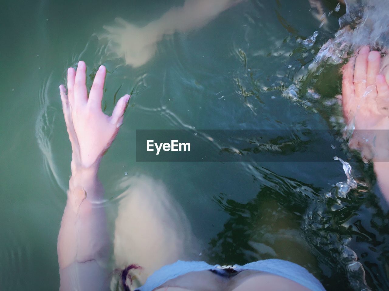 LOW SECTION OF PERSON SWIMMING UNDERWATER