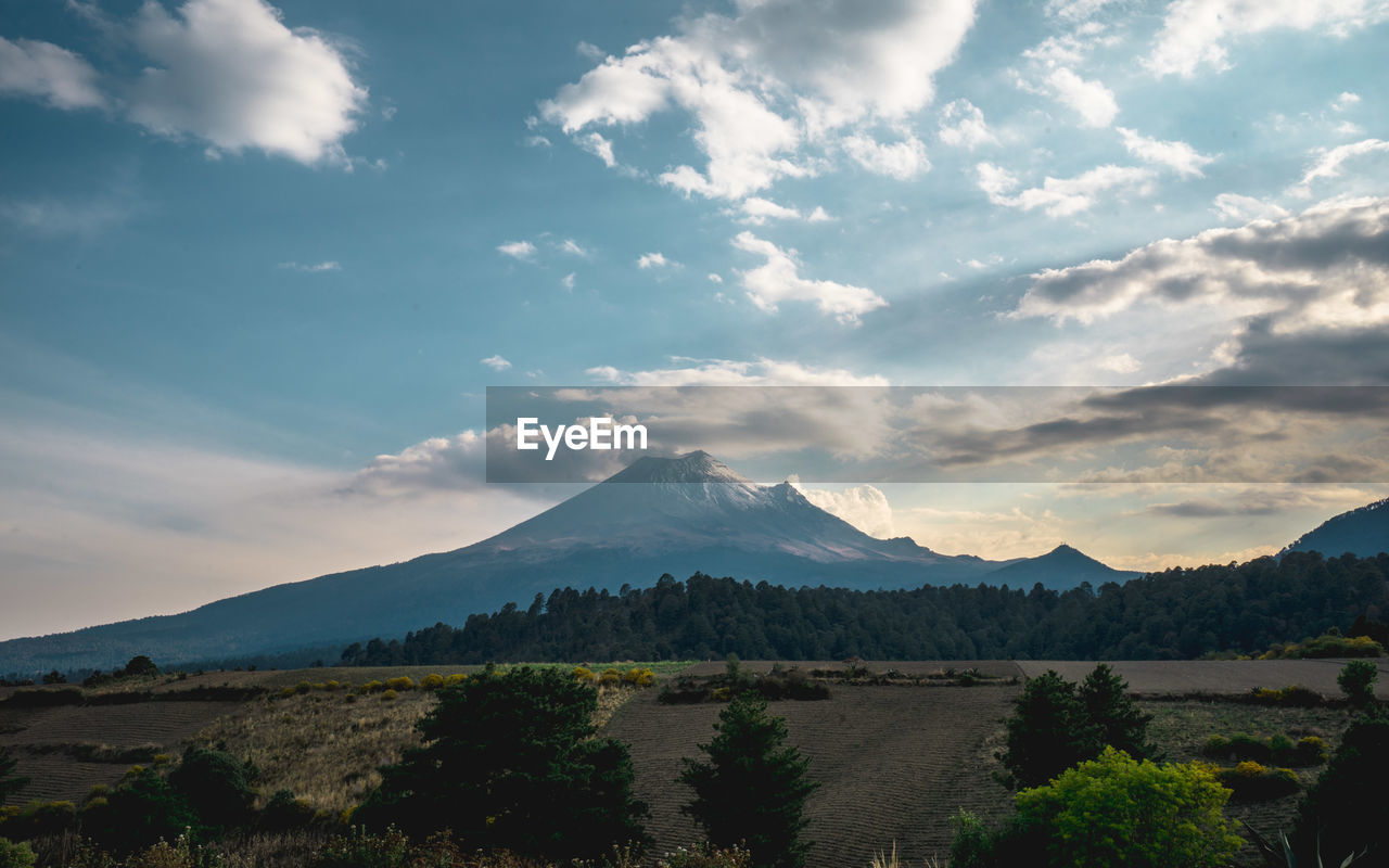 Scenic view of mountains against cloudy sky