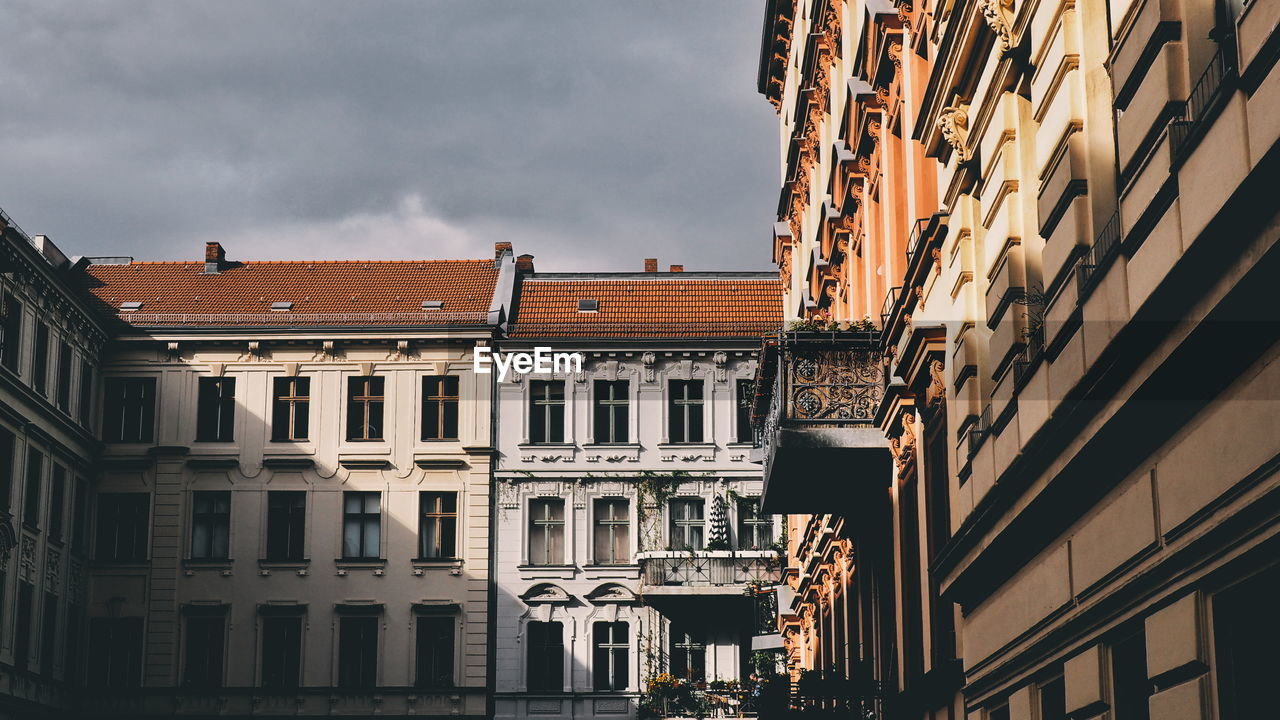 Low angle view of buildings against cloudy sky