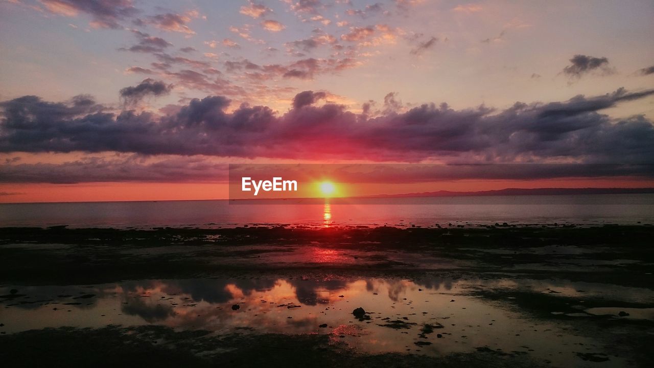 View of calm beach at sunset