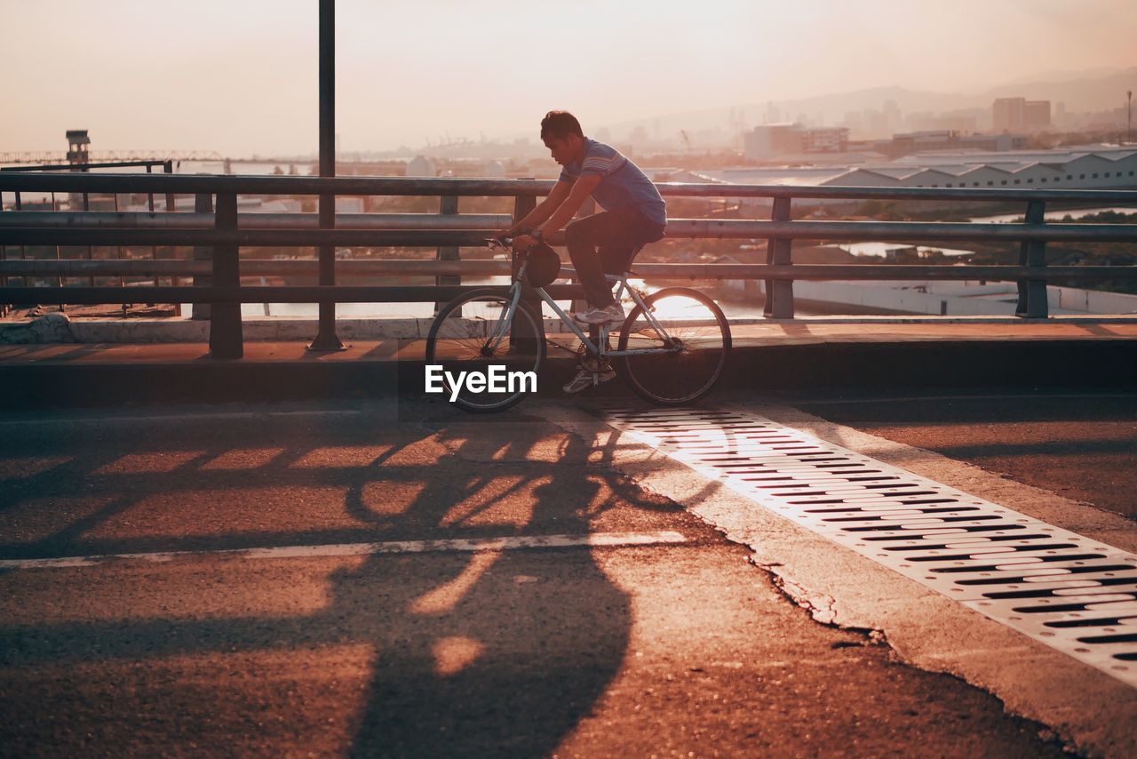 MAN RIDING BICYCLE ON RETAINING WALL