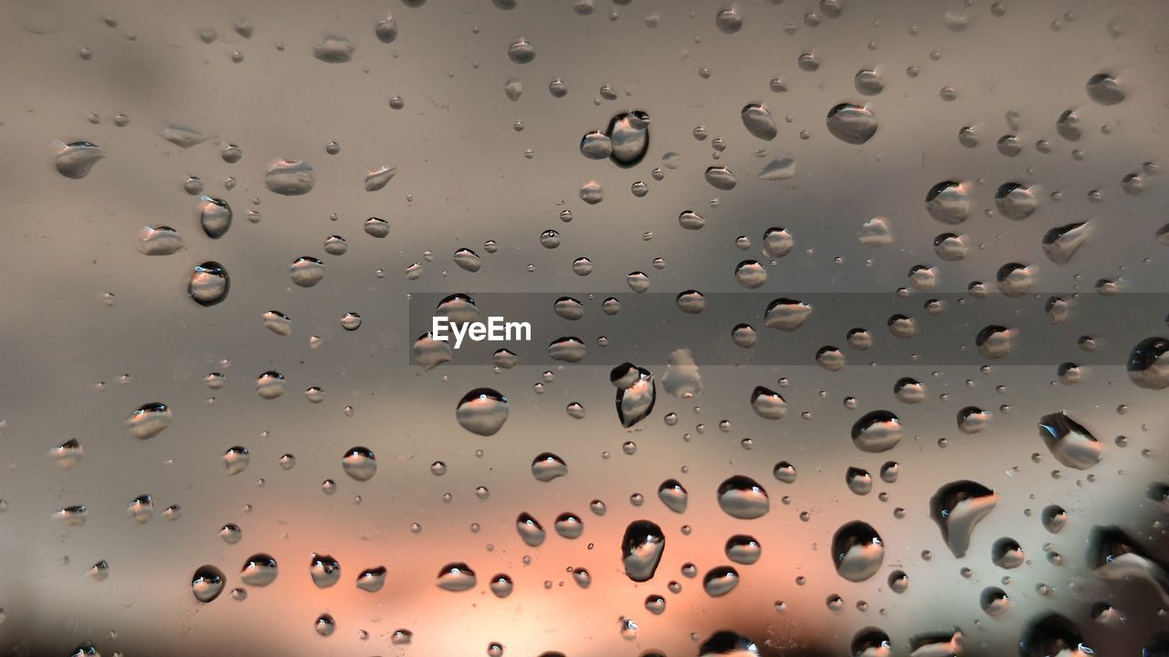 FULL FRAME SHOT OF WET GLASS WINDOW DURING RAINY SEASON