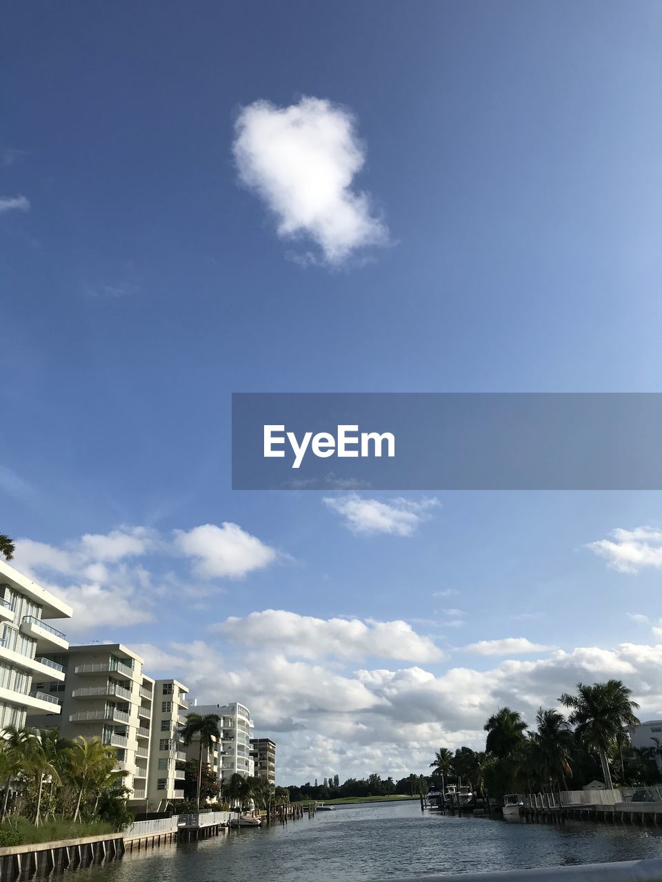 Buildings by sea against sky