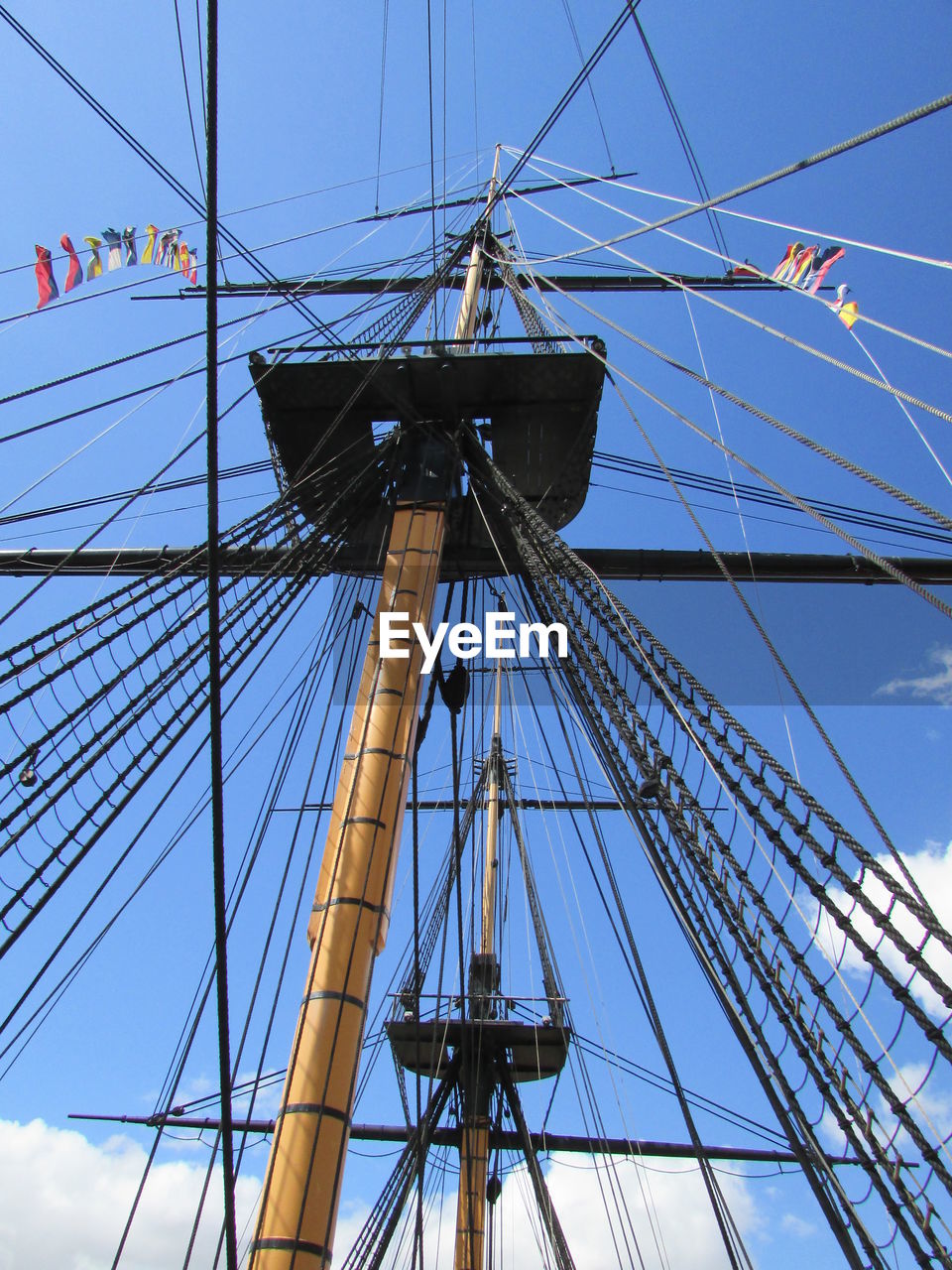 Low angle view of boats masts against sky