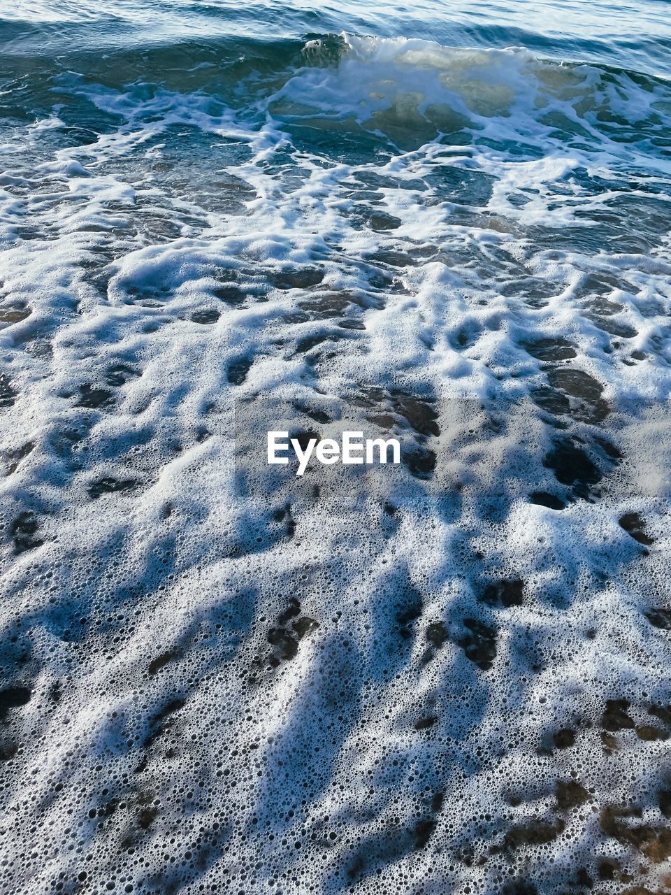 HIGH ANGLE VIEW OF SURF ON BEACH