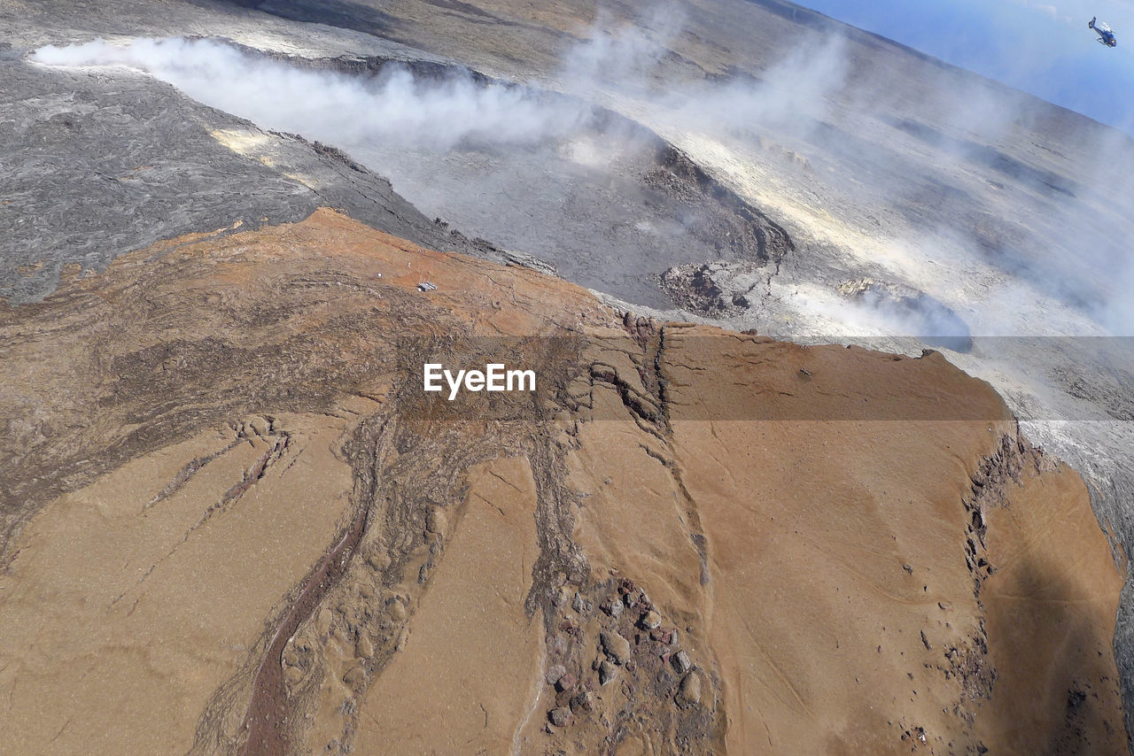 High angle view of steam emitting from volcanic landscape