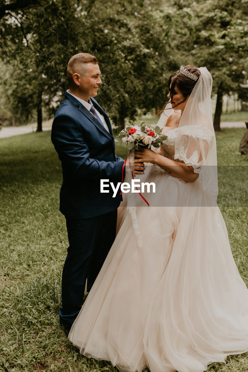 bride and bridegroom standing on field