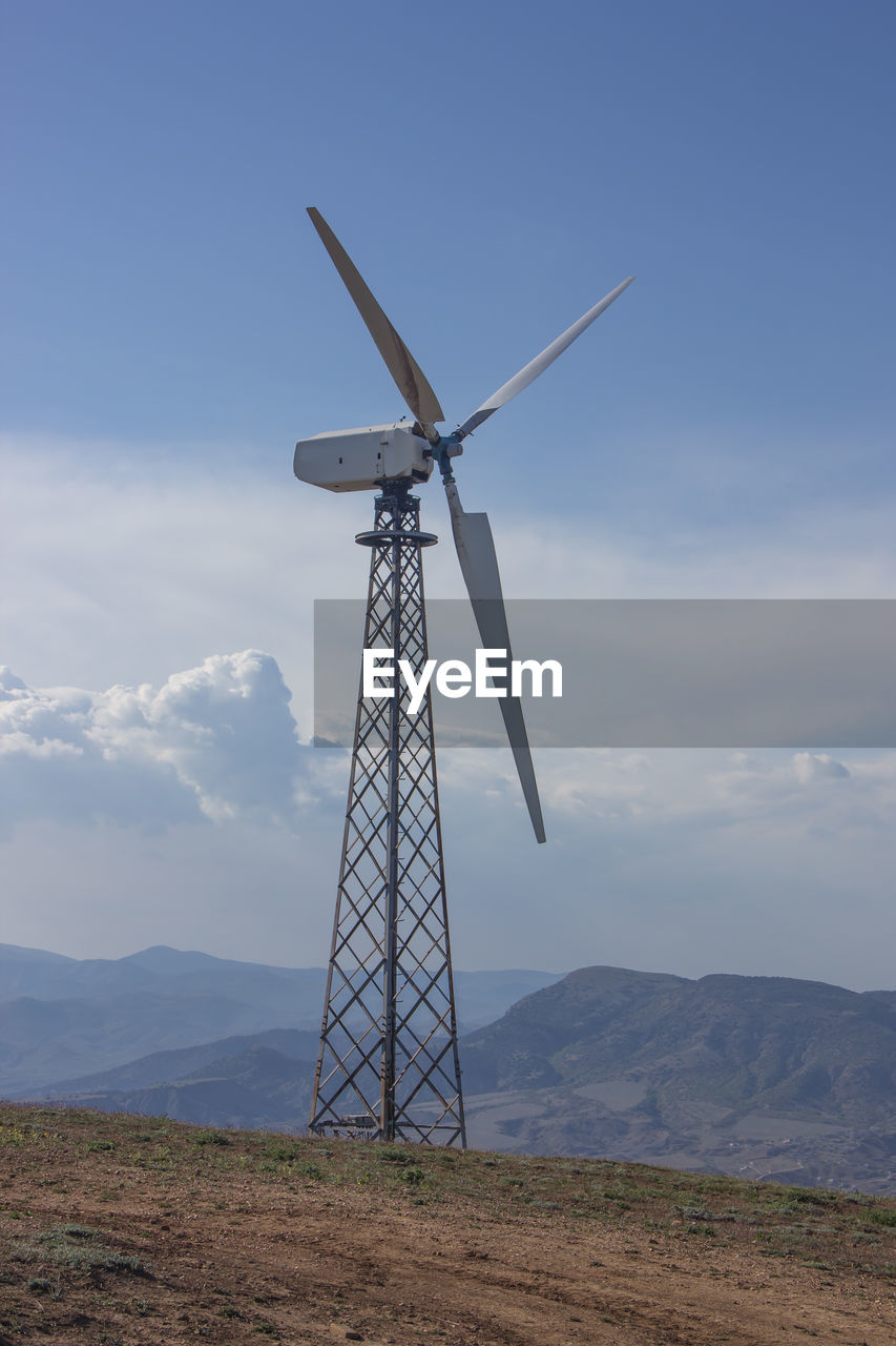 Windmill on field against sky