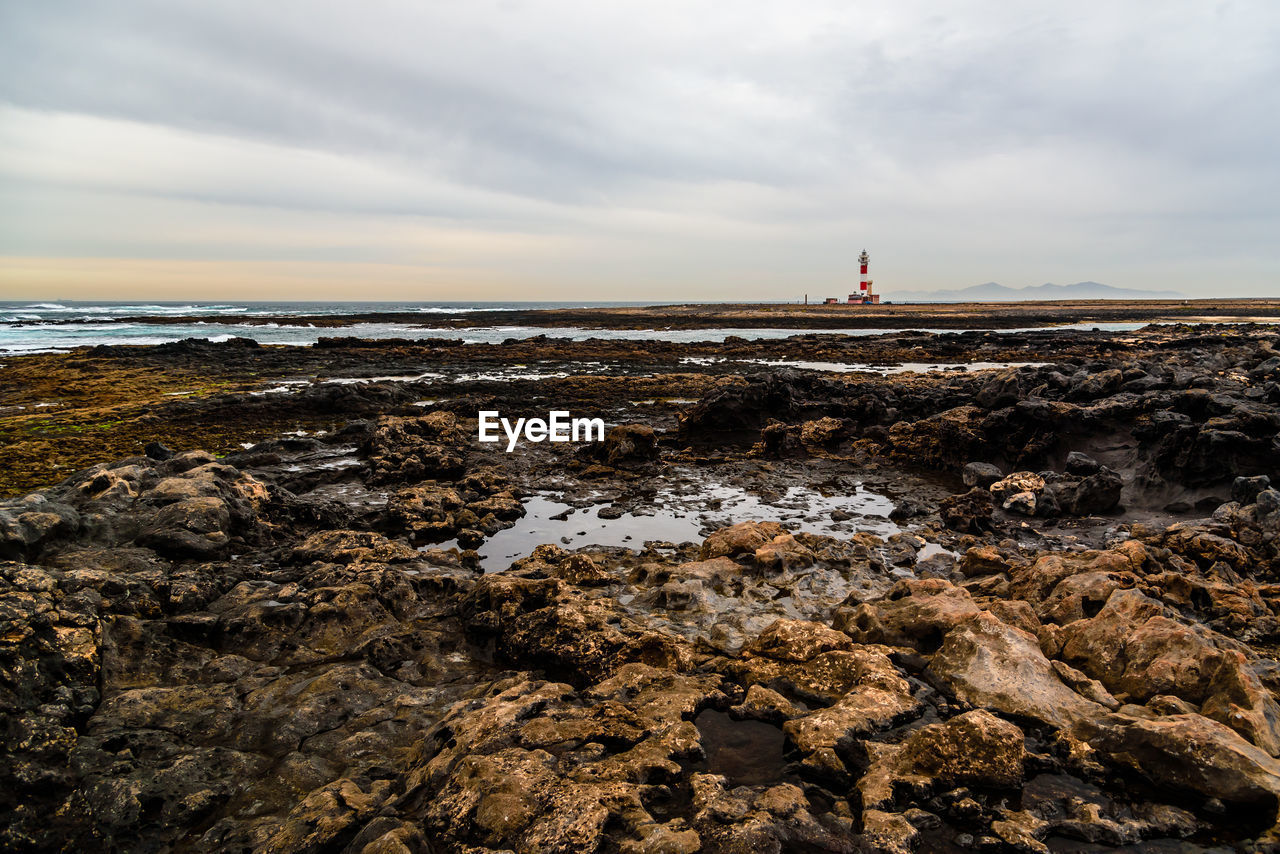 Scenic view of sea with rocky beach against sky. fuerteventura, canary islands, spain