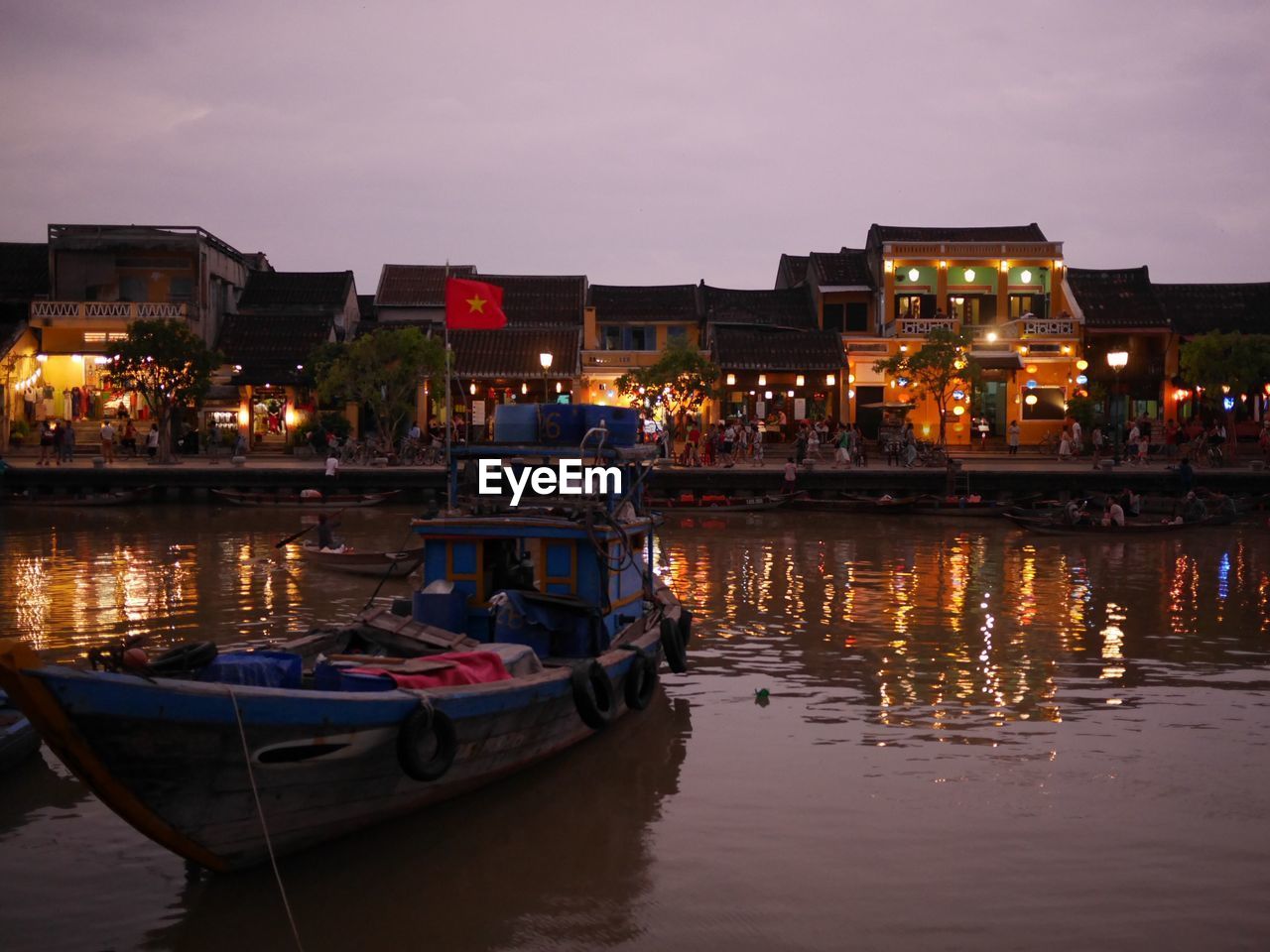 Boats moored on illuminated city at night