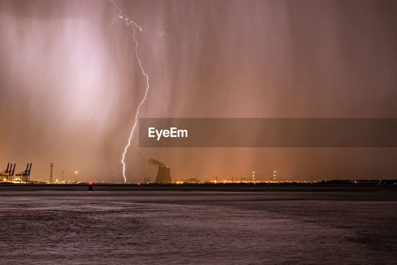 Lightning bolt strikes next to a nuclear power plant during a severe thunderstorm