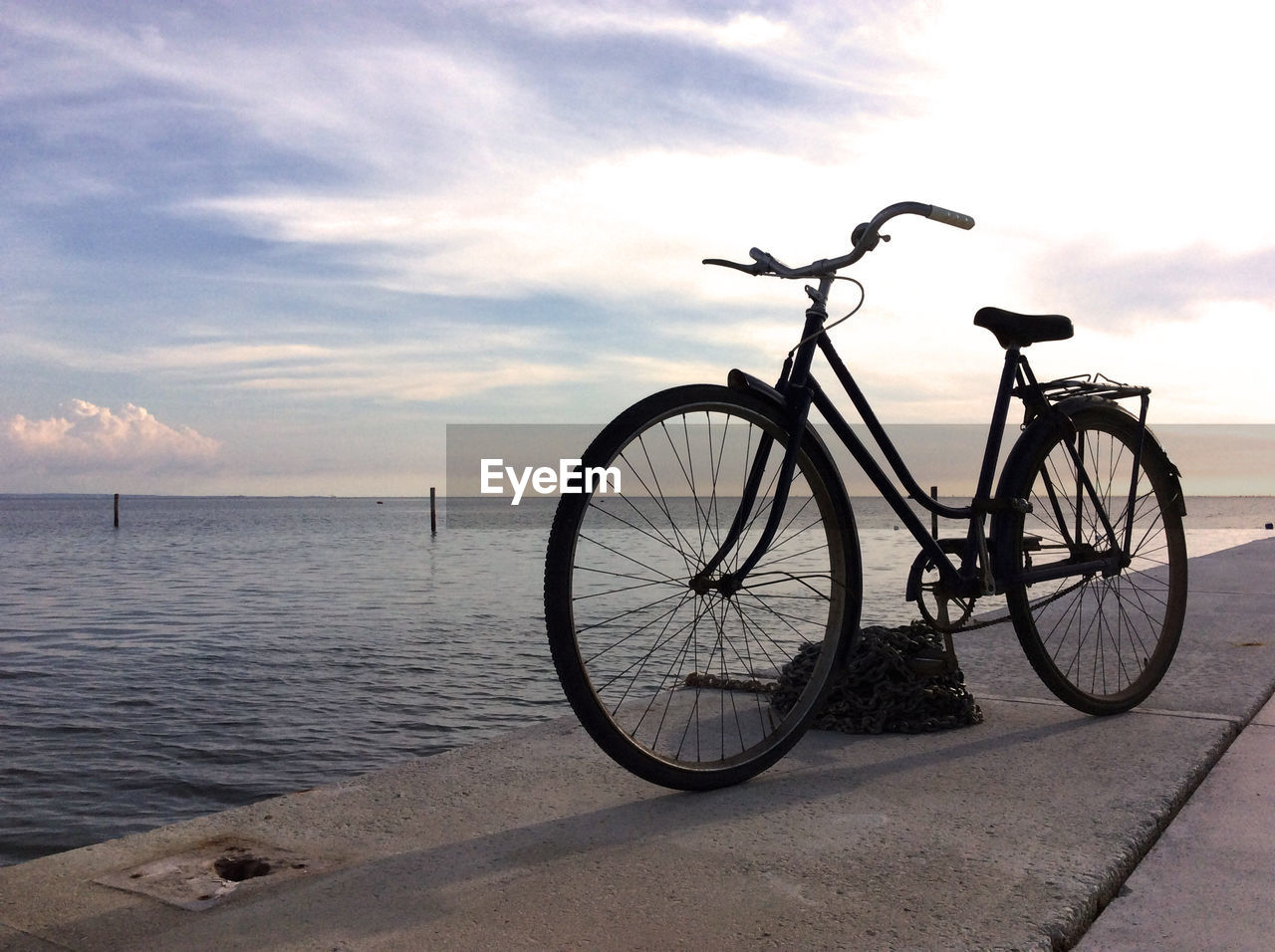 Bicycle on jetty against sea