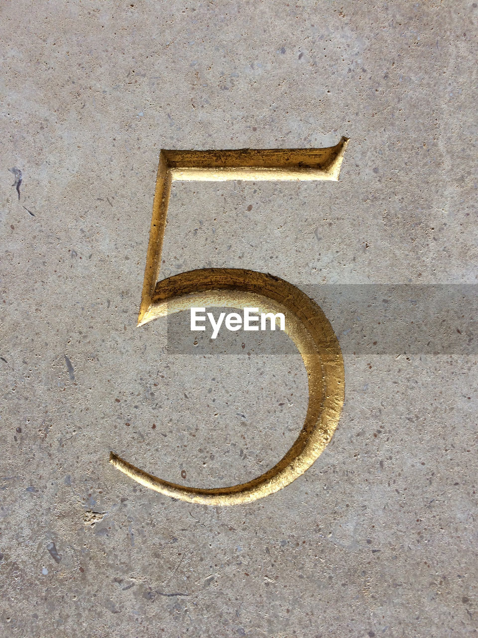 Close-up of number 5 on stone wall