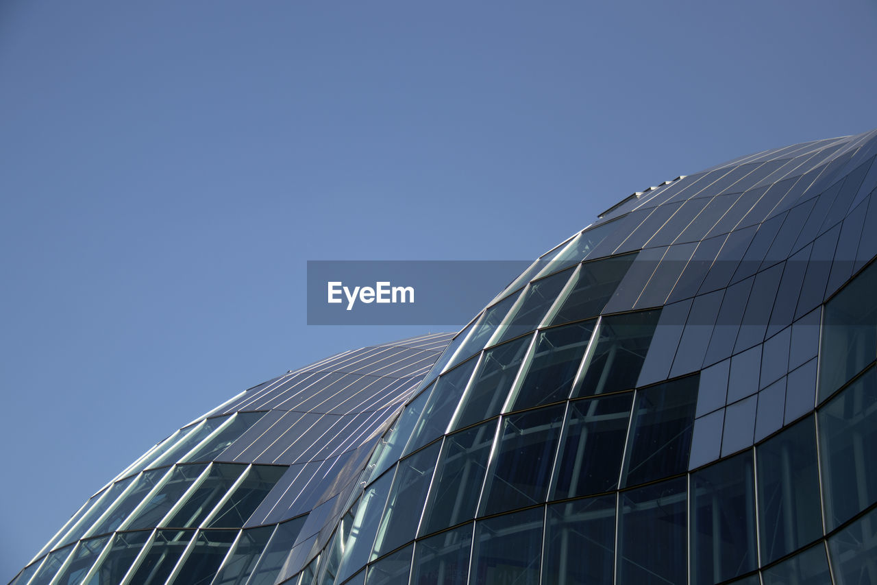 Low angle view of modern building against clear blue sky