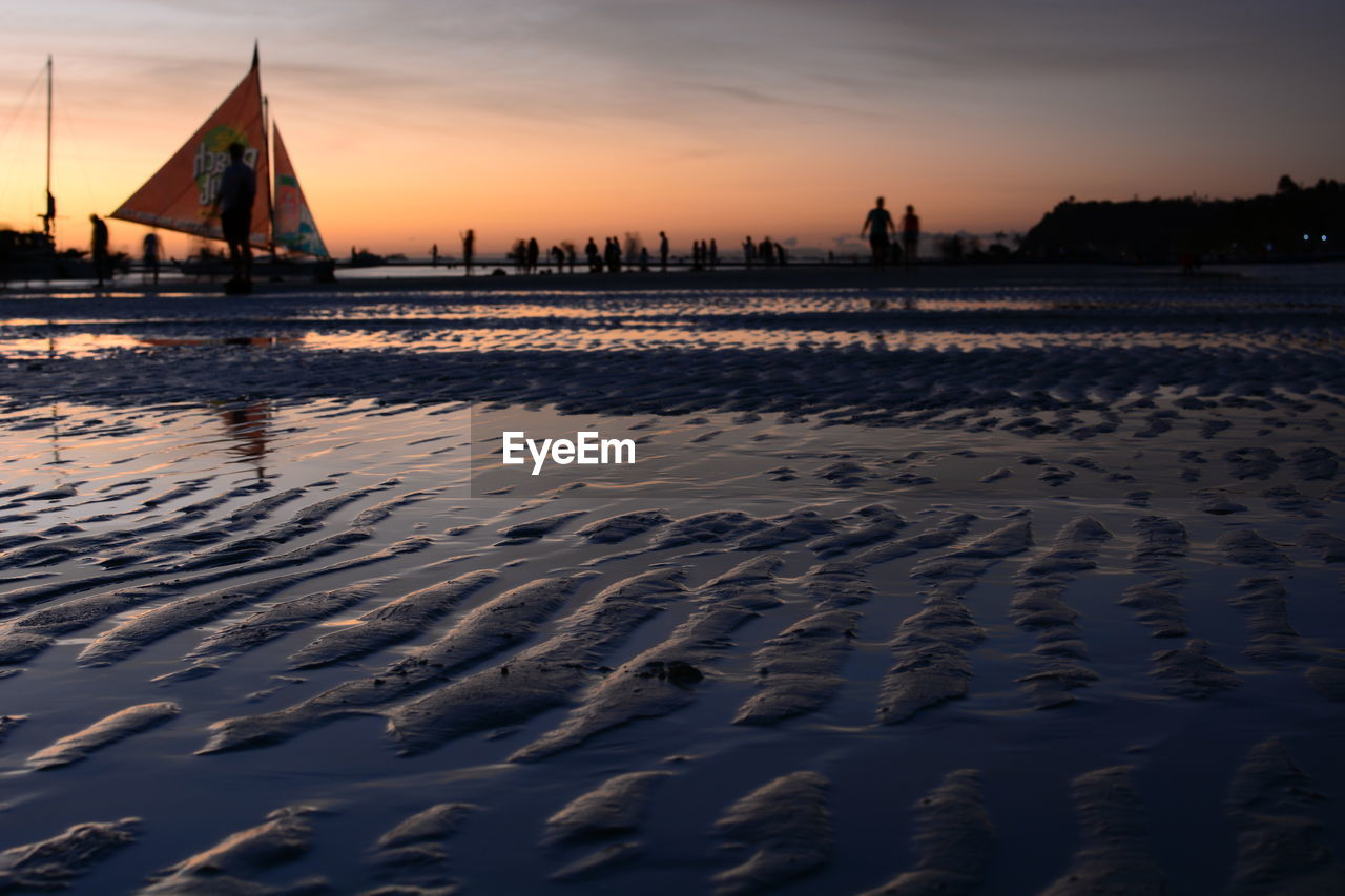 SCENIC VIEW OF BEACH AGAINST SKY DURING SUNSET