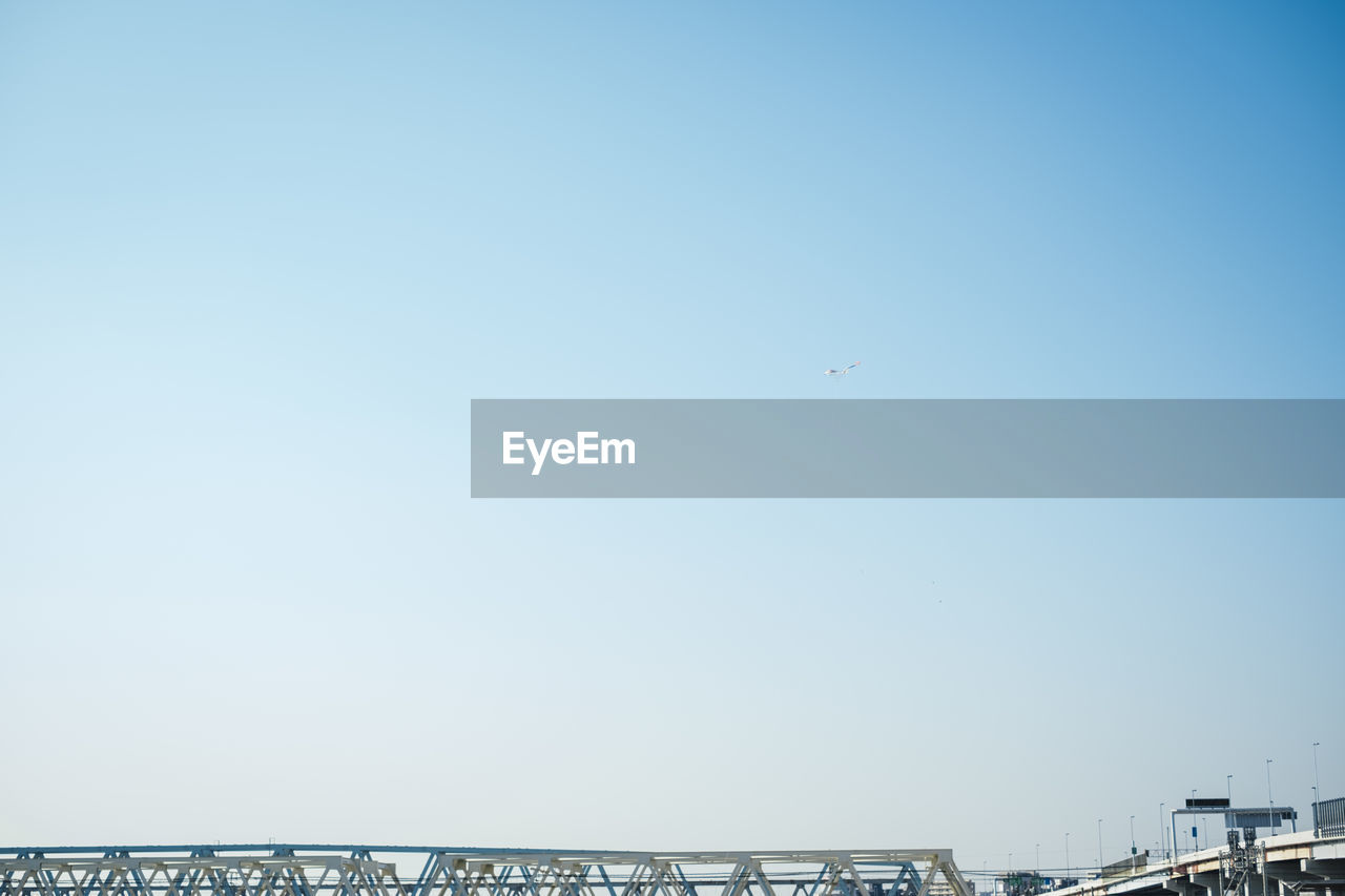 LOW ANGLE VIEW OF AIRPLANE FLYING IN CLEAR SKY