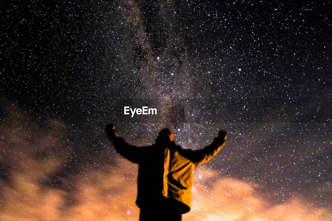 Rear view of man standing against star field